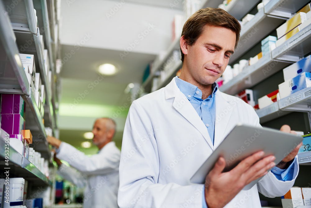 Fototapeta premium Dispensing duties just got smarter. Shot of a young pharmacist using a digital tablet in a pharmacy.