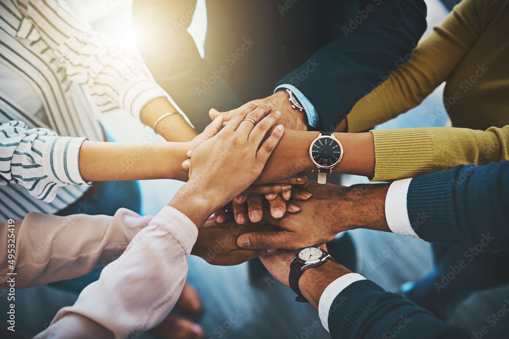Together as one is how well win. Closeup shot of an unrecognizable group of businesspeople joining their hands together in a huddle.