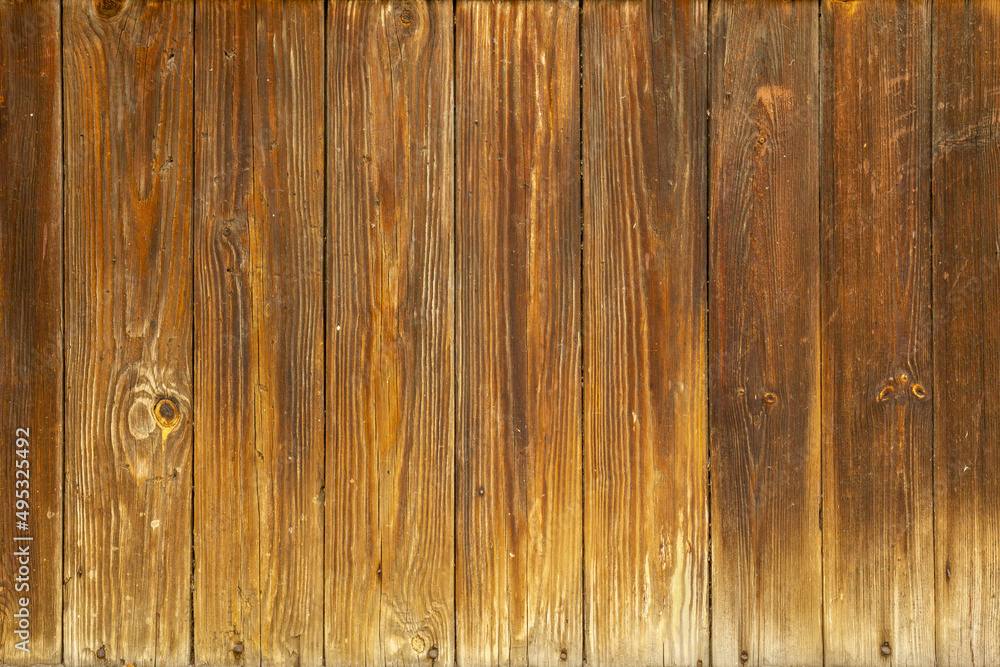 Authentic natural brown wood background with orange undertones. Old boards with a natural gradient on the surface from light to dark brown. Authentic natural brown wood background with orange undertones. Old boards with a natural gradient on the surface from light to dark brown.