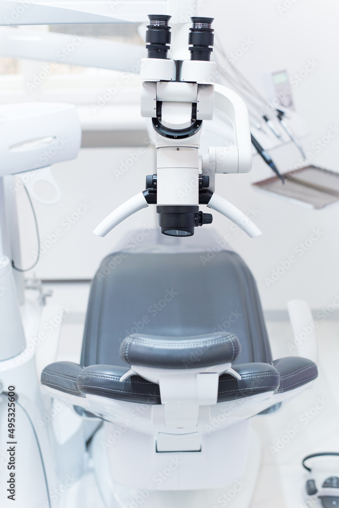 Dental binocular microscope on the background of modern dental clinic. Professional medical equipment.