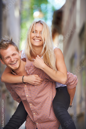 Having fun in the streets. A young man giving his beautiful girlfriend a piggyback ride in the street. © Mikolette M/peopleimages.com