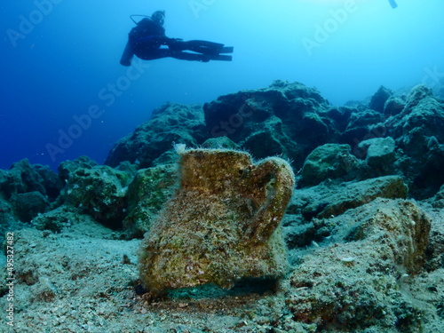 scuba diver underwater exploring ancient amphoras deep water history search