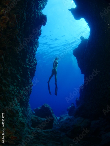 Bilde på lerret woman lady free diving apnea underwater in a cave cave with nice blue ocean scen