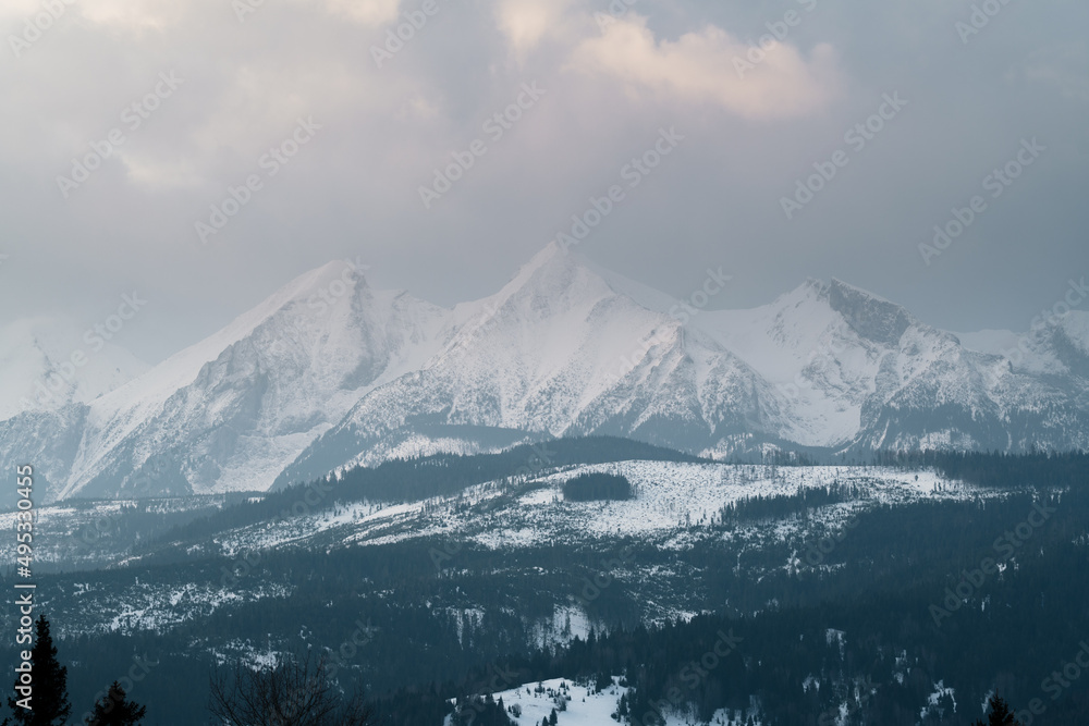 Tatry Wysokie o świcie, zima, szczyty w chmurach, Karpaty, widok z przełęczy nad Łapszanką.