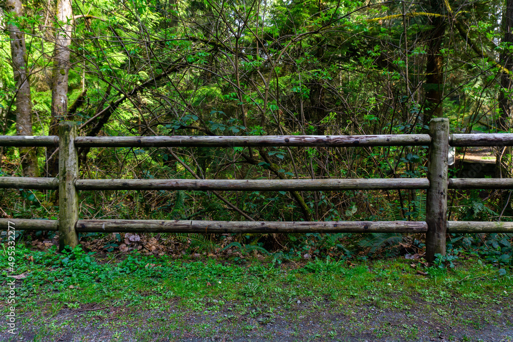 Three tier rail fence old in the middle of a park flat facing even proportions.