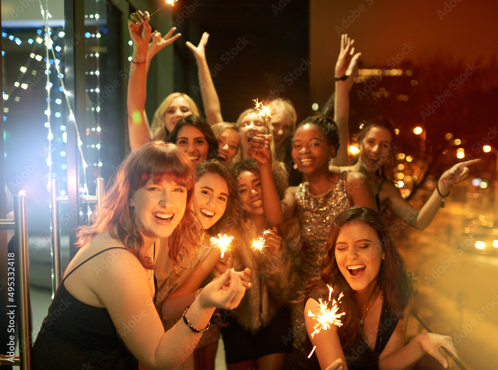 Obraz premium Sparkling into the New Year. Shot of a group of girlfriends having fun with sparklers on a balcony on a night out.