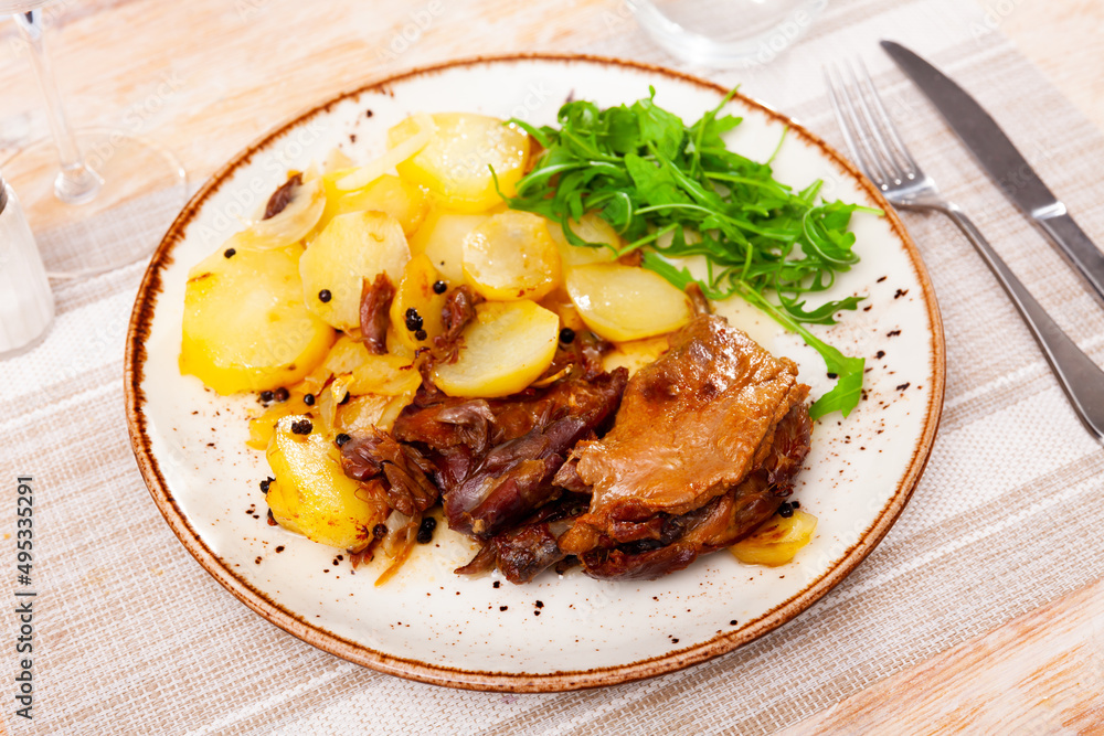 Confit duck leg with boiled potato, spices and arugula