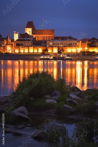 Beautiful urban night landscape. The old buildings of the Polish city of Toruń on the Vistula River.