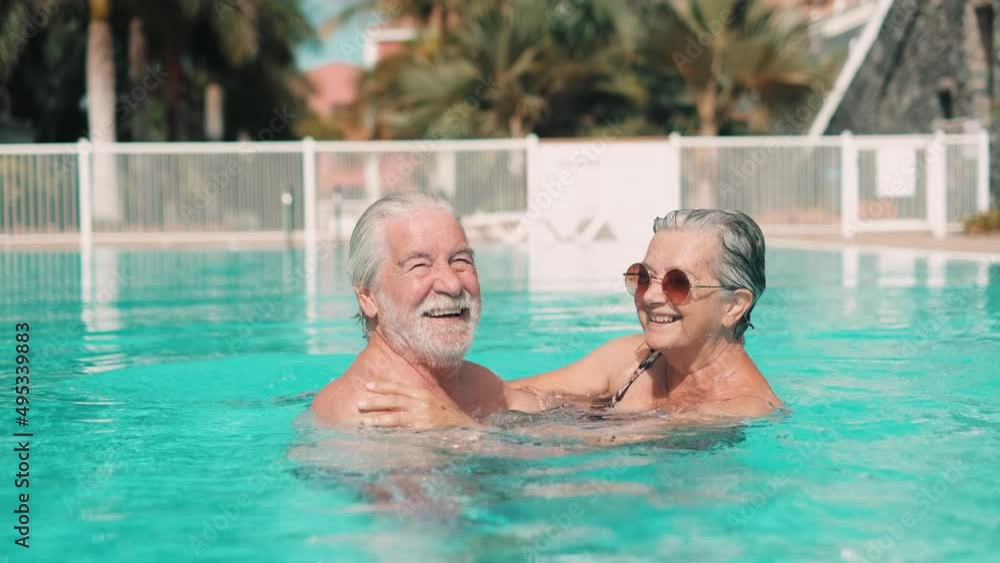 Couple of two happy seniors having fun and enjoying together in the swimming pool taking a selfie picture smiling and looking at the camera. Happy people enjoying summer outdoor in the water
Couple of two happy seniors having fun and enjoying together in the swimming pool taking a selfie picture smiling and looking at the camera. Happy people enjoying summer outdoor in the water