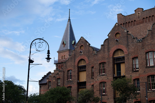 Heritage listed ASN Co Building. Pre Federation Anglo architecture in The Rocks, Sydney, Australia. Ornate old wrought iron street lamp stands outside. photo