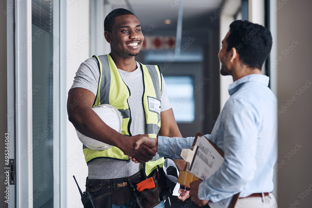 Obraz premium Well see you on Monday. Shot of two young architects standing together and shaking hands after a discussion about the room before they renovate.
