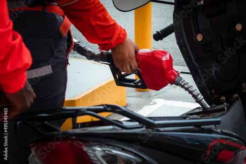 mano de persona echándole gasolina a una moto en gasolinera