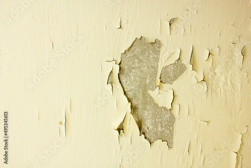 Exfoliating paint. Flying material on the wall close-up. Old cracked wall material.