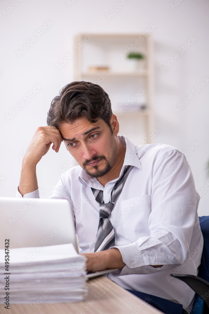 Young male employee working in the office Young male employee working in the office