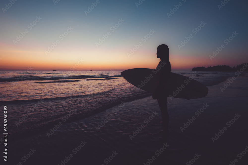 Silhouette of beautiful sexy surfer female with surfboard on the sandy beach at sunset. water sports. Surfing are healthy active lifestyle. Summertime vacation. retro color effect.