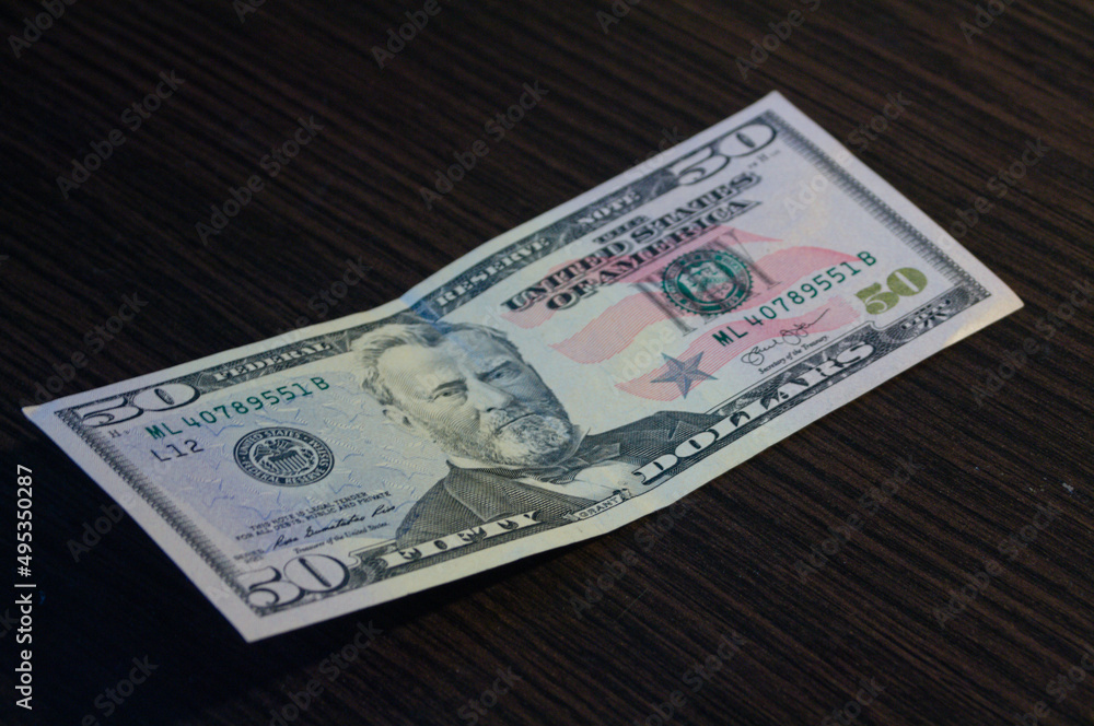 Fifty dollar banknote on dark wooden table texture Fifty dollar banknote on dark wooden table texture