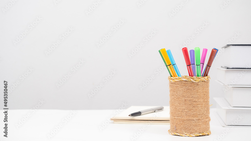 Pencil box pen books on the table copy space white background