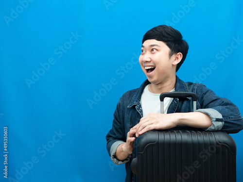 Man with hugging luggage cheerful looking at copy space holiday concept