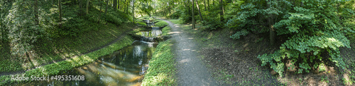 aerial panoramic view of picturesque scenery with a calm cascade stream in a summer nature park