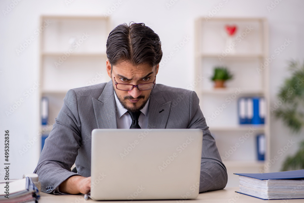 Young male employee working in the office Young male employee working in the office