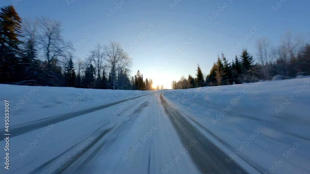 Point of view: driving on country snow-covered track along the trees in the morning sunny time . High quality 4k footage Point of view: driving on country snow-covered track along the trees in the morning sunny time . High quality 4k footage