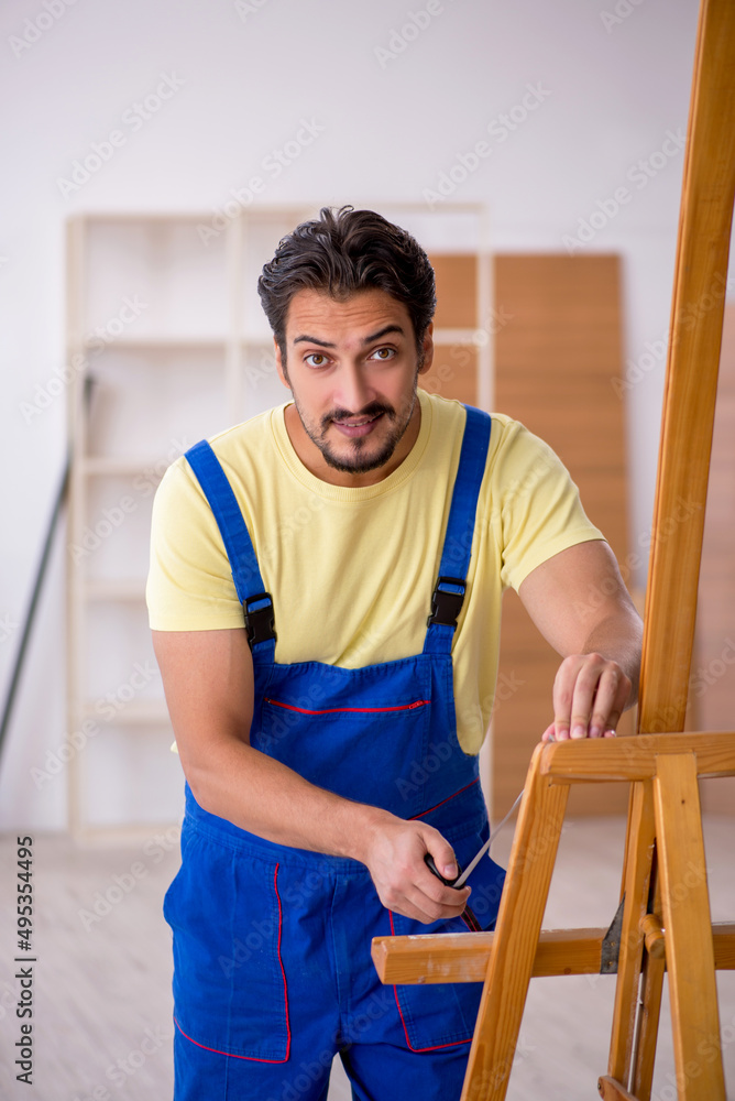 Young male repairman repairing easel at home Young male repairman repairing easel at home