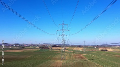 Power Lines In Field With Clear Blue Sky - drone shot