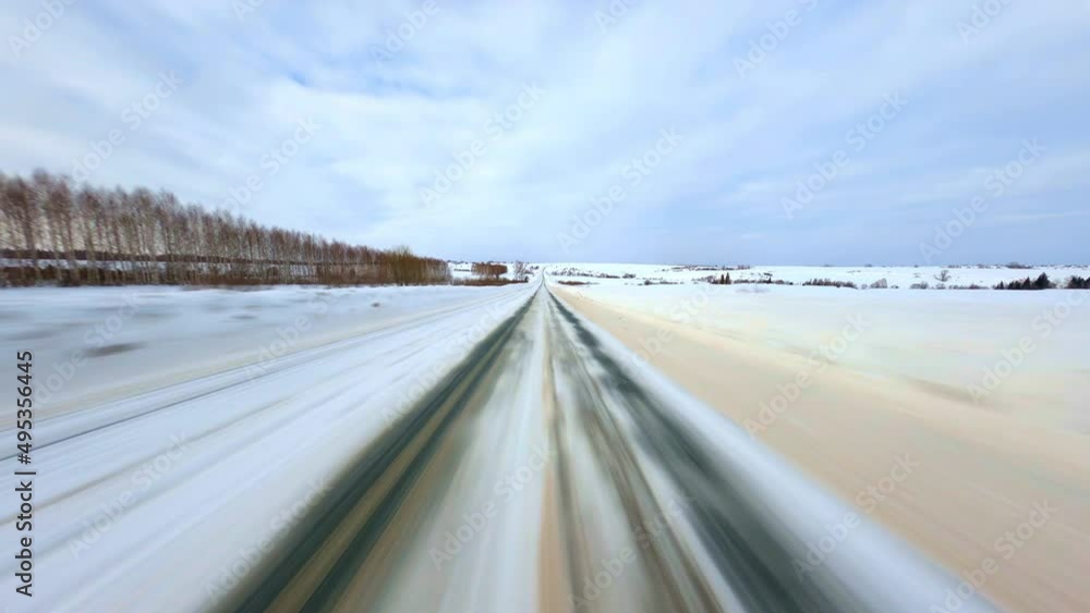 Point of view: driving on country snow-covered track along the trees in the morning sunny time . High quality 4k footage Point of view: driving on country snow-covered track along the trees in the morning sunny time . High quality 4k footage