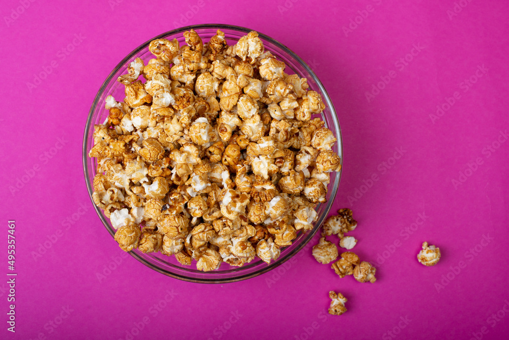 popcorn in a bowl on a pink background popcorn in a bowl on a pink background
