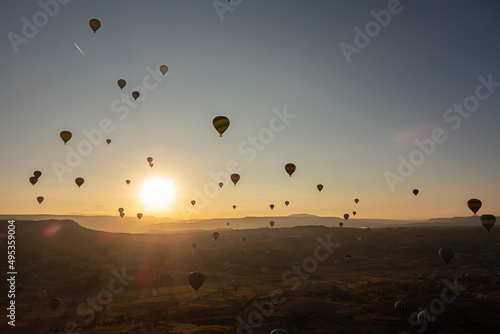 Hot air balloons in the sky during sunrise. Flying over the valley at Cappadocia  Anatolia  Turkey. Volcanic mountains in Goreme national park.