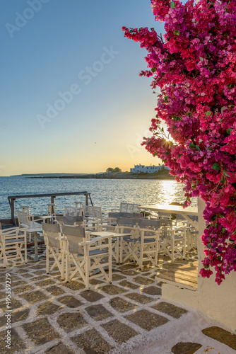 Traditional Cycladitic view with an exterior of a bar besides the sea  during afternoon in Naousa  Paros island, Greece © valantis minogiannis