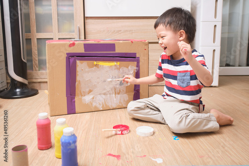 Cute Asian boy child enjoy using paintbrush painting on cardboard box at home, Fun art and crafts for little kids, Children's Art Project, DIY Toys from Recyclable Materials,  Home schooling concept