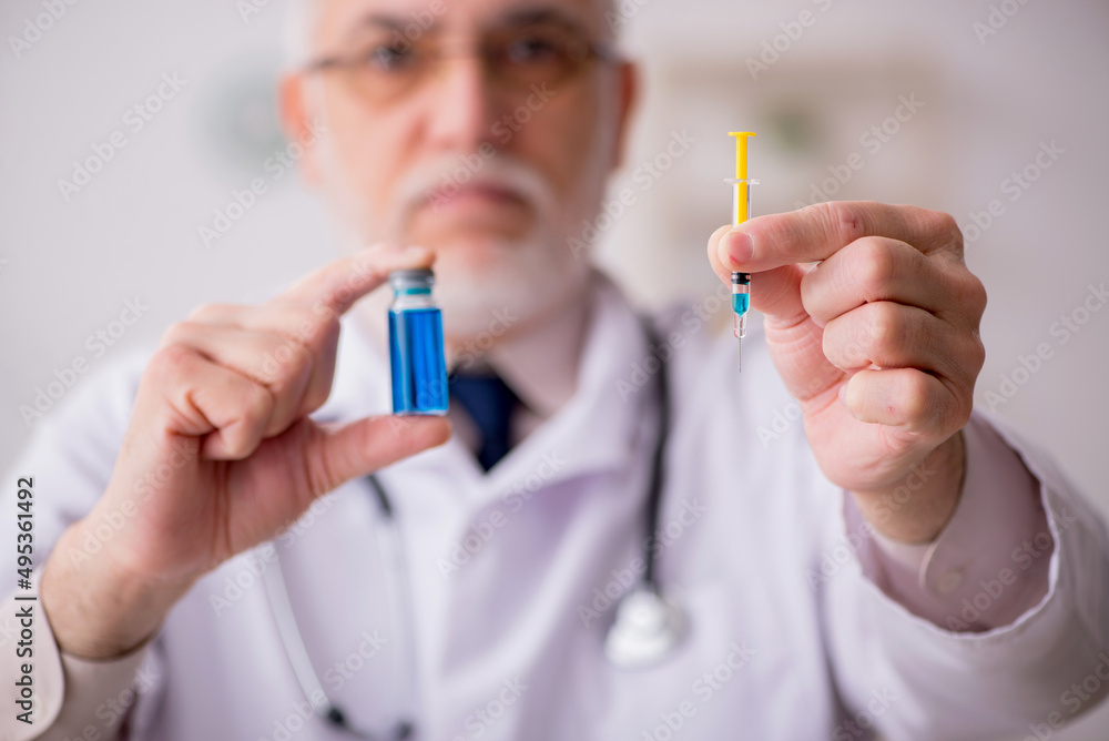 Old male doctor in vaccination concept Old male doctor in vaccination concept