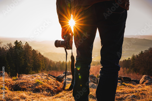 Photographer with camera in sunset taking photos of landscape. Travel Lifestyle hobby concept adventure active vacations outdoor photo