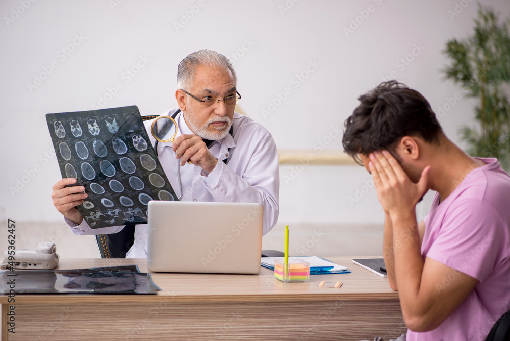 Young male patient visiting old male doctor radiologist Young male patient visiting old male doctor radiologist