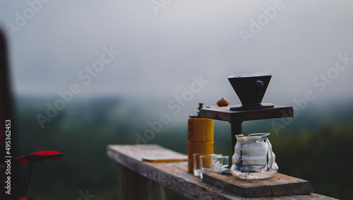 Drip coffee set on wooden table with mountain landscape on dark tone