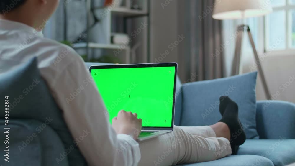 Man Waving Hand And Talking To Green Screen Laptop While Lying On Sofa In The Living Room
Man Waving Hand And Talking To Green Screen Laptop While Lying On Sofa In The Living Room