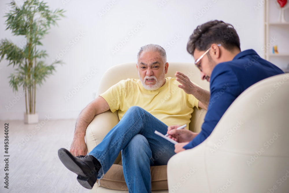 Old man visiting young male psychotherapist Old man visiting young male psychotherapist
