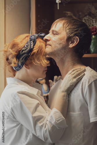 A couple in love in white shirts and jeans, a date in a pottery workshop, working together on one potter's wheel photo