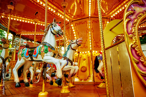 Carousel with colorful horses at amusement park, Merry go round with horse, Vintage ride attraction for children