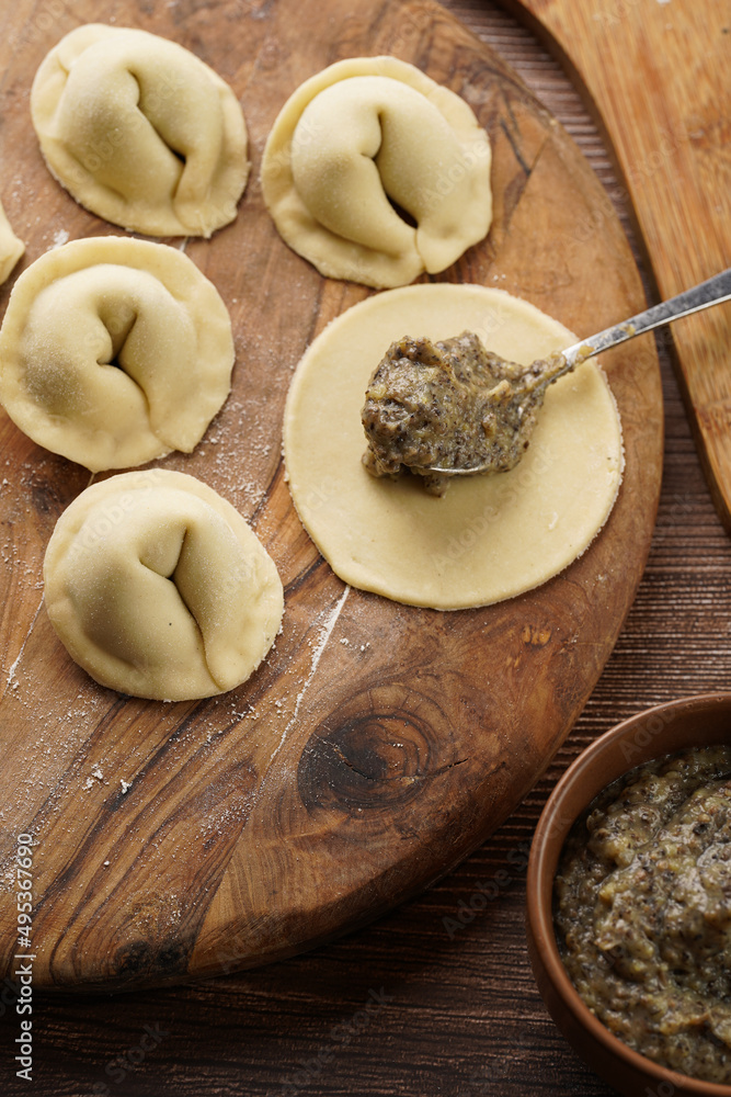 Process of preparation of traditional ukrainian east european dish varenyky - dumplings stuffed with potato-mushroom paste. Wooden background Process of preparation of traditional ukrainian east european dish varenyky - dumplings stuffed with potato-mushroom paste. Wooden background