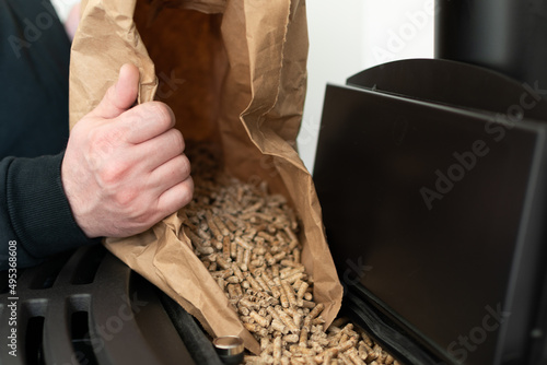 Man loading pellet stove with granule bag