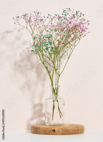 bouquet of dried flowers in a glass transparent vase on a white table