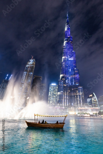 Fototapeta Traditional boat and Burj Khalifa illumination with fountain show in Dubai