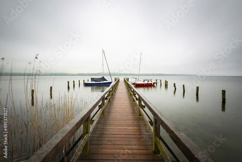 Germany, Schleswig-Holstein, Jetty on shore of Ratzeburger See during foggy weather photo