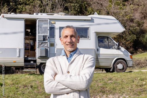 Confident man with arms crossed in front of motor home photo