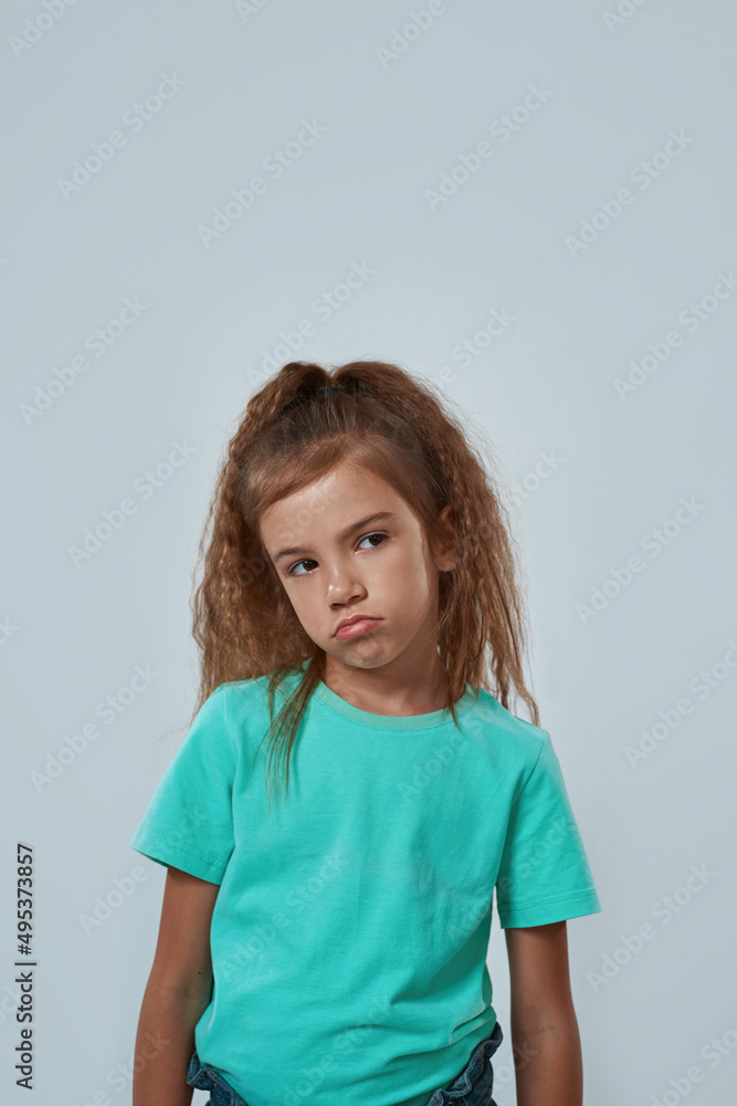 Front view of offended little girl looking away Front view of offended little girl looking away