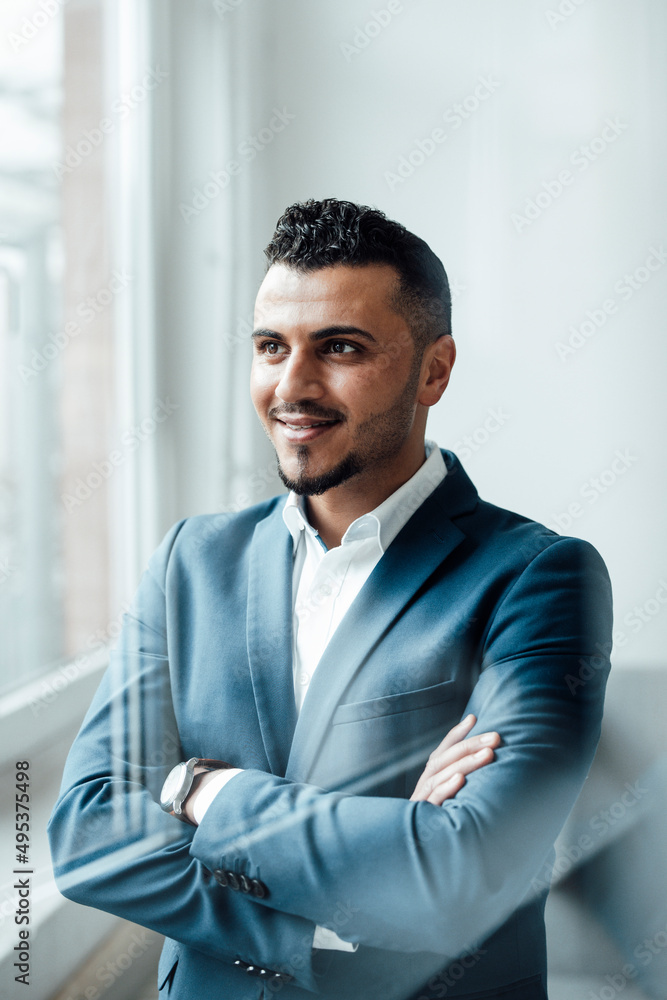 Businessman standing with arms crossed in office Businessman standing with arms crossed in office