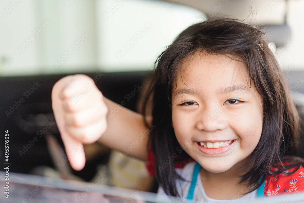 Asian kid tween girl thumb down with smile on seat.Family Riding Car Traveling Automobile. Asian family parenting and children with funny face.Angry selfish child.Sibling kid.spoiled child.bad feel. Asian kid tween girl thumb down with smile on seat.Family Riding Car Traveling Automobile. Asian family parenting and children with funny face.Angry selfish child.Sibling kid.spoiled child.bad feel.