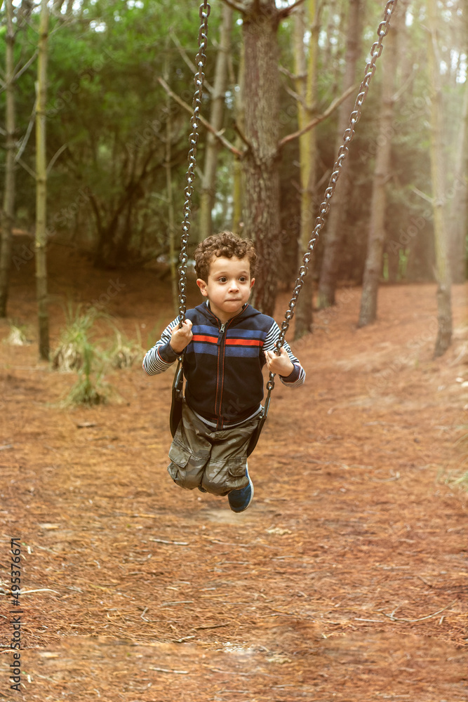 child on swing in forest